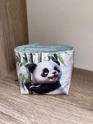 Panier et ses lingettes Joyeux Panda, accroché au bambou